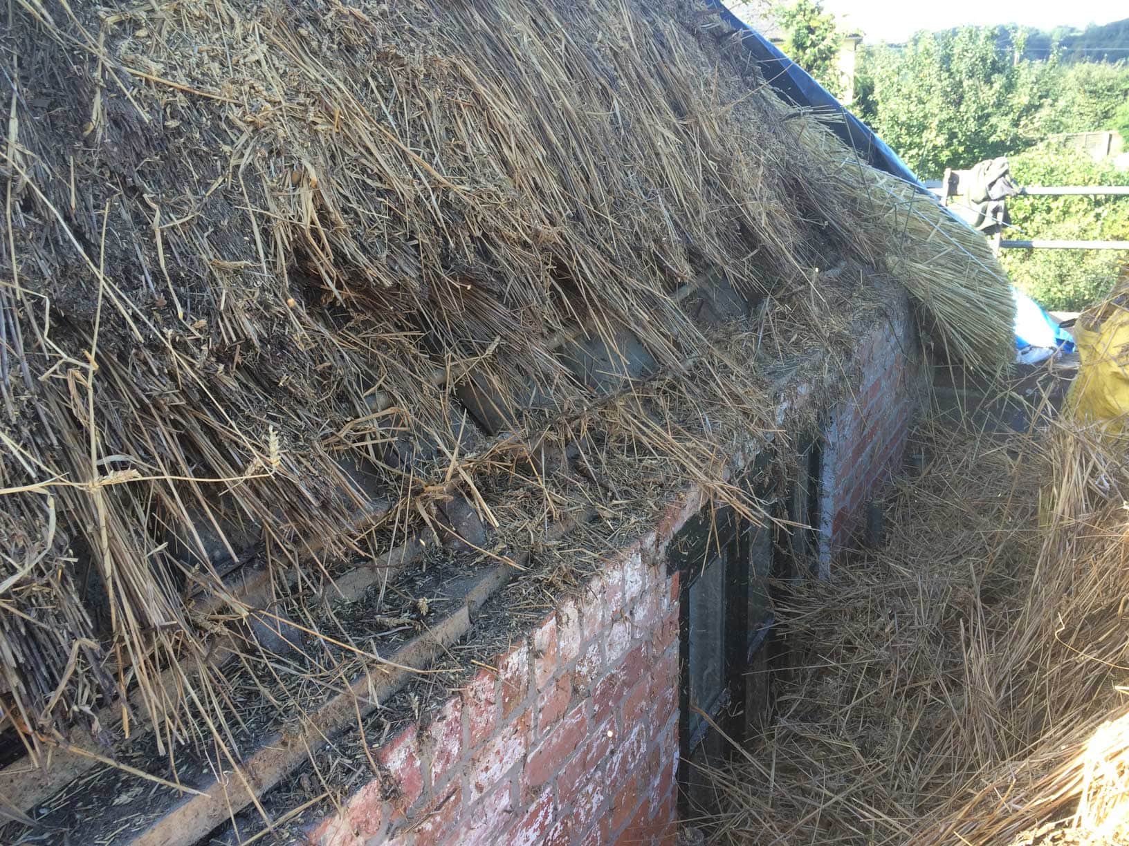 Building up the thatch in layers to ensure maximum insulation and longevity.